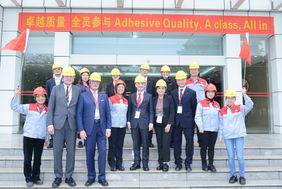 Gruppenbild mit OB Geisel vor dem Henkel-Werk in Guangzhou, alle Abgebildeten tragen Bauarbeiterhelme