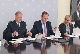 Helge Scharfscheer, Vizepräsident Bundespolizeidirektion Sankt Augustin, OB Dr. Stephan Keller und Polizeipräsidentin Miriam Brauns (v.l.) unterschreiben die Kooperationsvereinbarung zum Projekt "SiBu". Foto: Alhadjiui