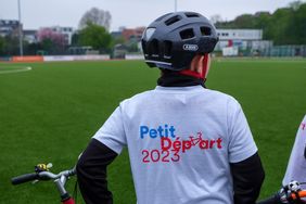 Foto das ein Kind mit Petit Départ-T-shirt zeigt