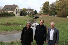 Oberbürgermeister Dr. Stephan Keller (Mitte) mit Stadtkämmerin Dorothée Schneider und Frank Heuner, Technischer Leiter SEBD, an der Südlichen Düssel. Foto: Ingo Lammert