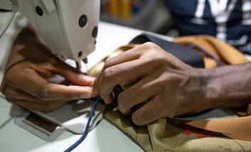 Foto von Händen bei der Arbeit an einer Nähmaschine