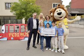 Schüler der KGS Fleher Straße nehmen mit Schulleiterin Astrid Zörner (obere Reihe, 3.v.l.) den Preis für den zweiten Platz entgegen. Jochen Kral, Antonia Schnelle und Lookie gratulieren. Foto: Ingo Lammert