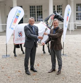 OB Thomas Geisel (r.) und Klaus Allofs, Vorstand des Düsseldorfer Reiter- und Rennvereins, präsentieren vor dem Waagegebäude den Rheinturm für den 100. Gewinner des Traditionsrennens um den "Großen Preis der Landeshauptstadt".